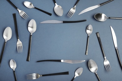 Frame made of steel cutlery on grey background, top view. Space for text