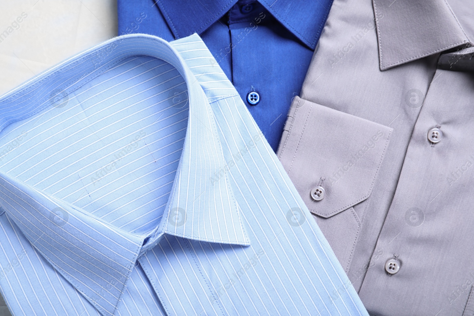 Photo of Stylish shirts on table, flat lay. Dry-cleaning service