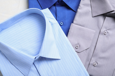 Photo of Stylish shirts on table, flat lay. Dry-cleaning service