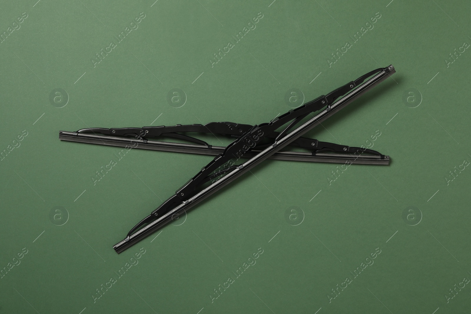 Photo of Car windshield wipers on dark green background, flat lay