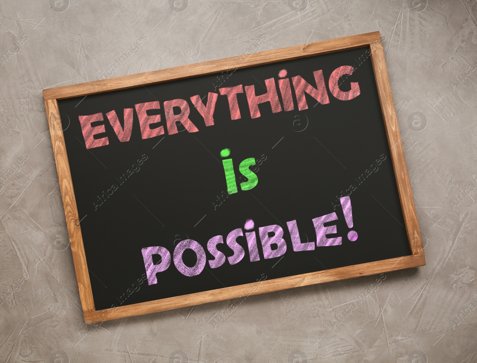 Image of Small chalkboard with motivational quote Everything is possible on grey background, top view