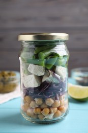 Photo of Glass jar with healthy meal on light blue wooden table