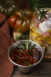 Tasty fish marinade with rosemary in bowl on wooden table, closeup