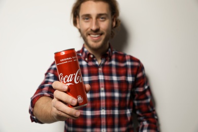 MYKOLAIV, UKRAINE - NOVEMBER 28, 2018: Young man with Coca-Cola can on white background