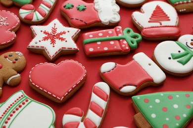 Photo of Different Christmas gingerbread cookies on red background, closeup