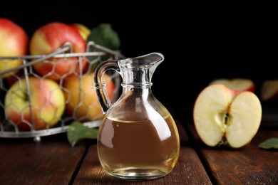 Photo of Natural apple vinegar and fresh fruits on wooden table