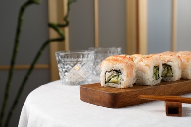 Photo of Delicious sushi rolls with shrimps served on white table indoors, space for text