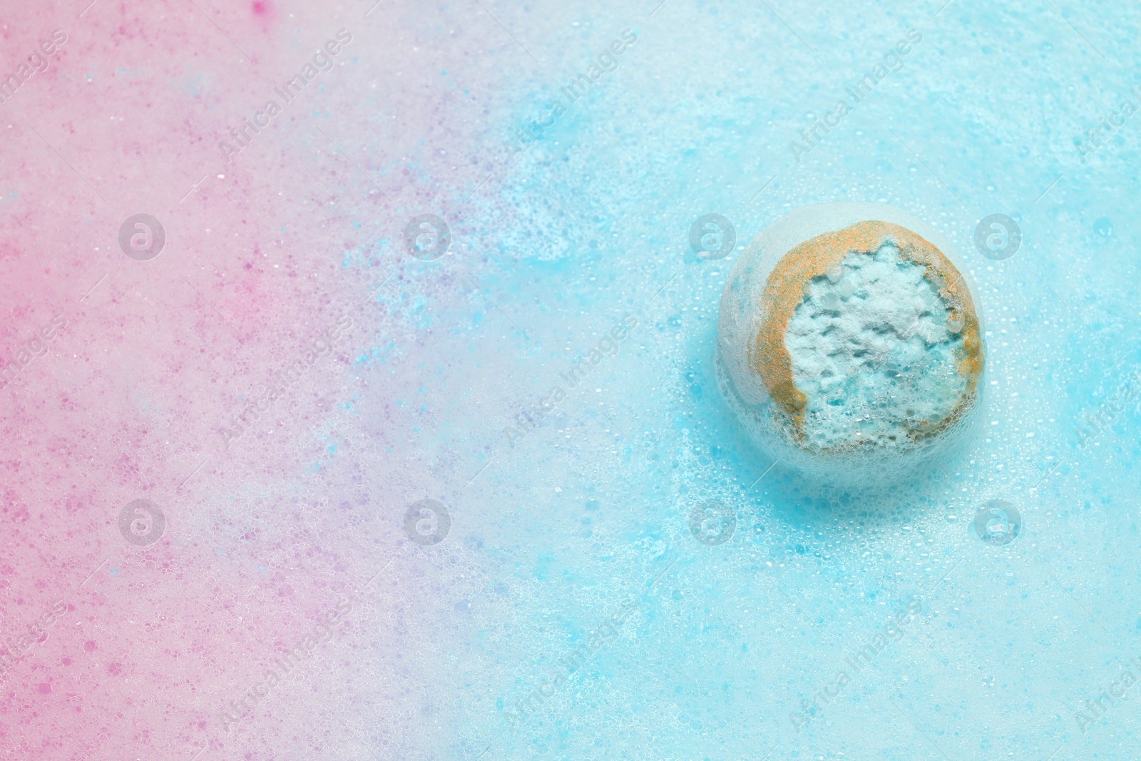 Photo of Light blue bath bomb dissolving in water. Space for text