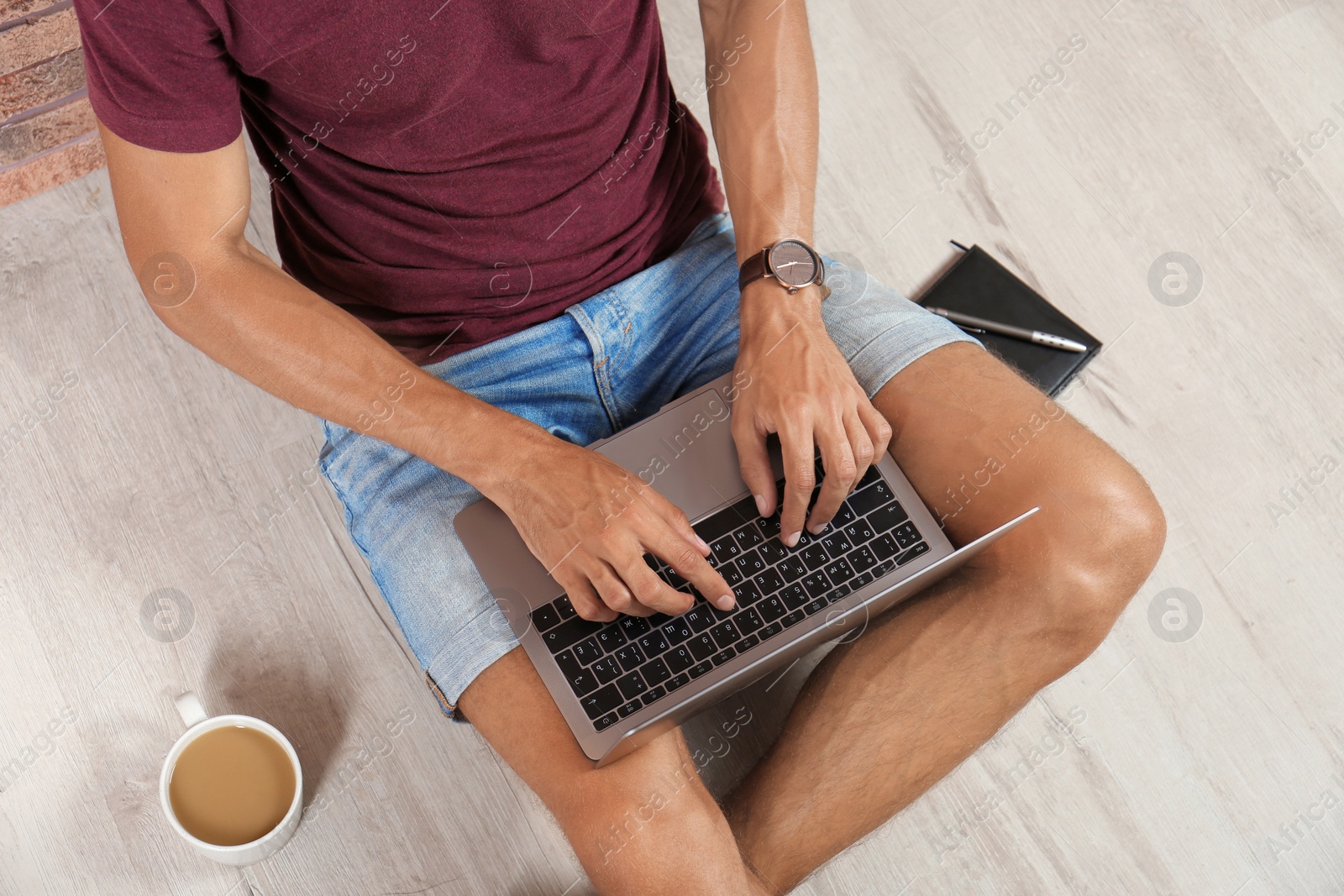 Photo of Young man with laptop sitting on floor