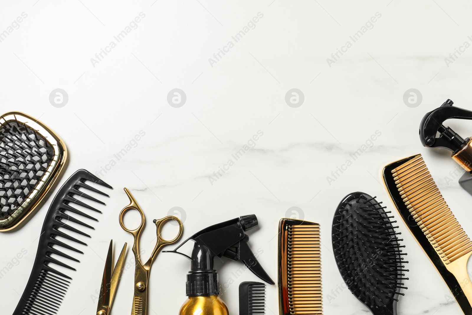 Photo of Hairdressing tools on white marble table, flat lay. Space for text