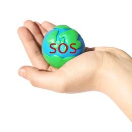 Image of Woman holding plasticine model of planet Earth with word SOS on white background, closeup