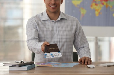 Photo of Travel agent with tickets and passports in office, closeup