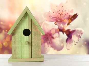 Image of Beautiful bird house on wooden table outdoors, space for text