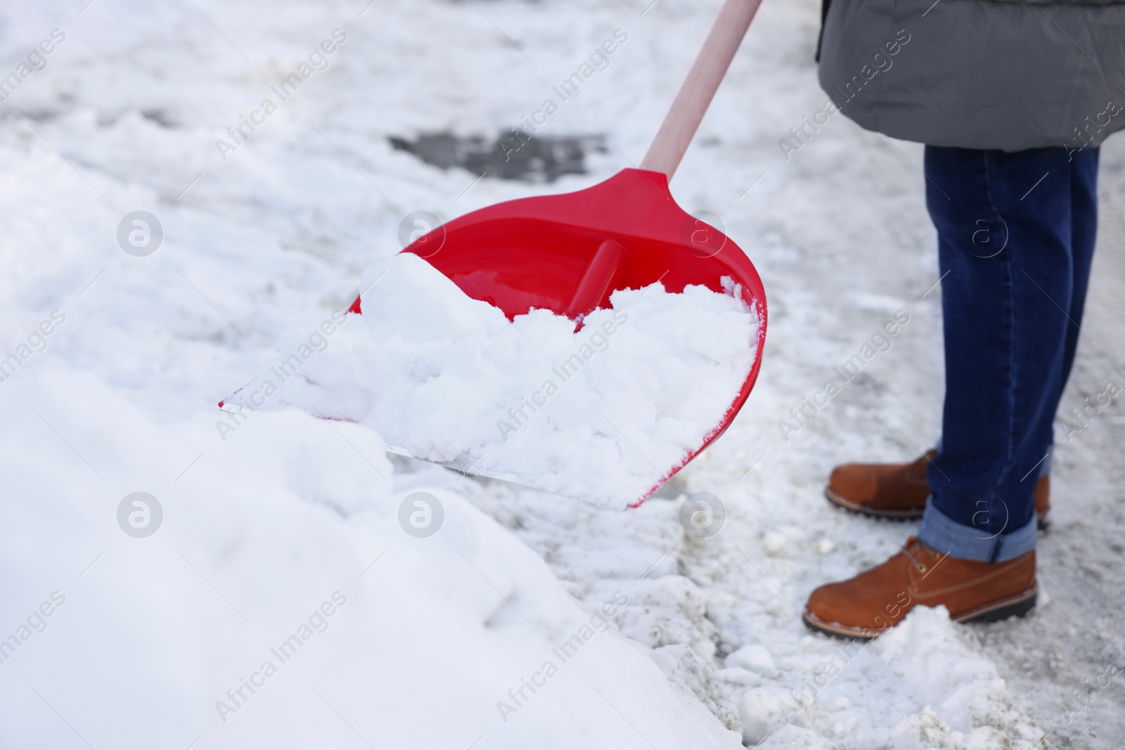 Photo of Man removing snow with shovel outdoors, closeup