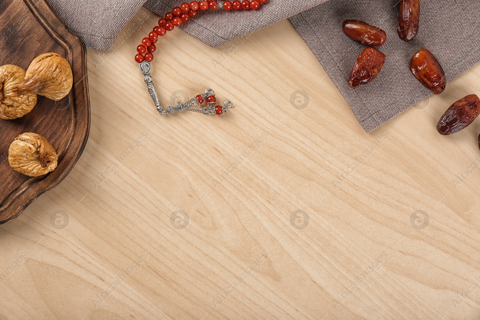 Photo of Flat lay composition with Muslim prayer beads, fruits and space for text on wooden background