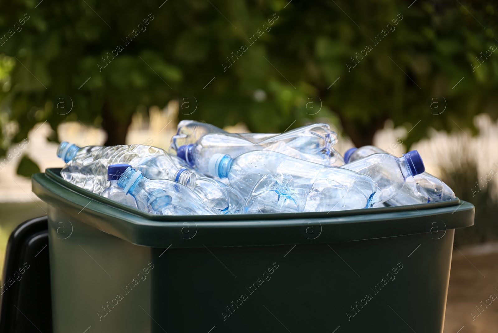 Photo of Many used plastic bottles in trash bin outdoors, closeup. Recycling problem