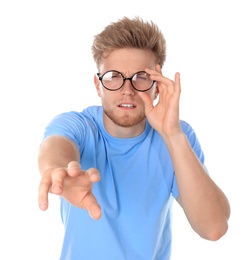 Photo of Young man with vision problem wearing glasses on white background