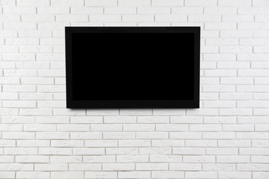 Image of Modern TV on white brick wall. Space for design