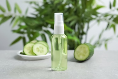 Cucumber tonic in bottle on table against blurred background