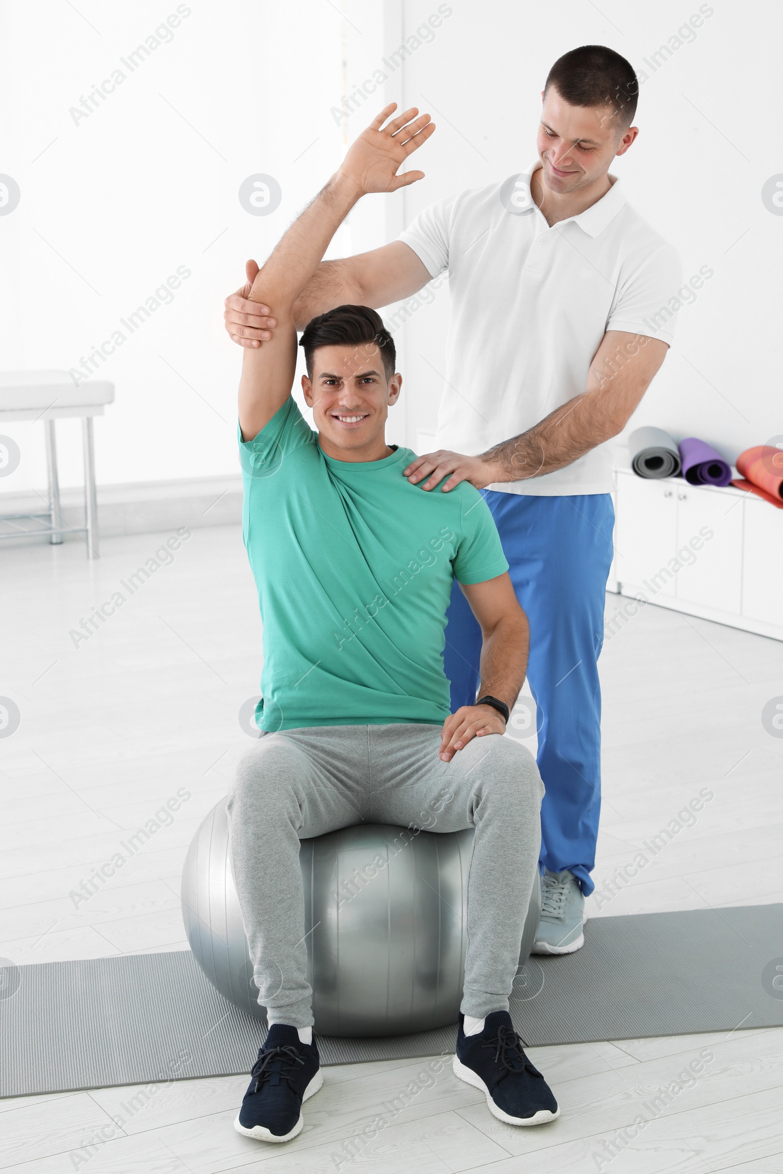 Photo of Professional physiotherapist working with male patient in rehabilitation center