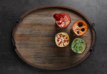 Photo of Tray with many different delicious smoothies on grey table, top view. Space for text