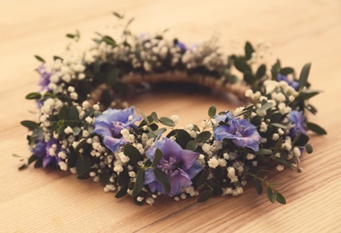 Beautiful flower wreath on wooden background, closeup