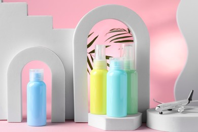 Photo of Cosmetic travel kit and geometric figures on pink background. Bath accessories