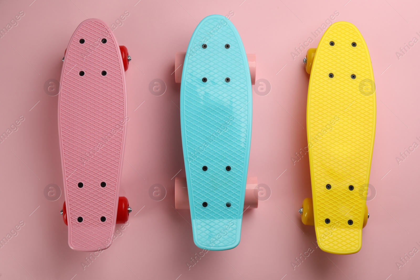 Photo of Color skateboards on pink background, flat lay