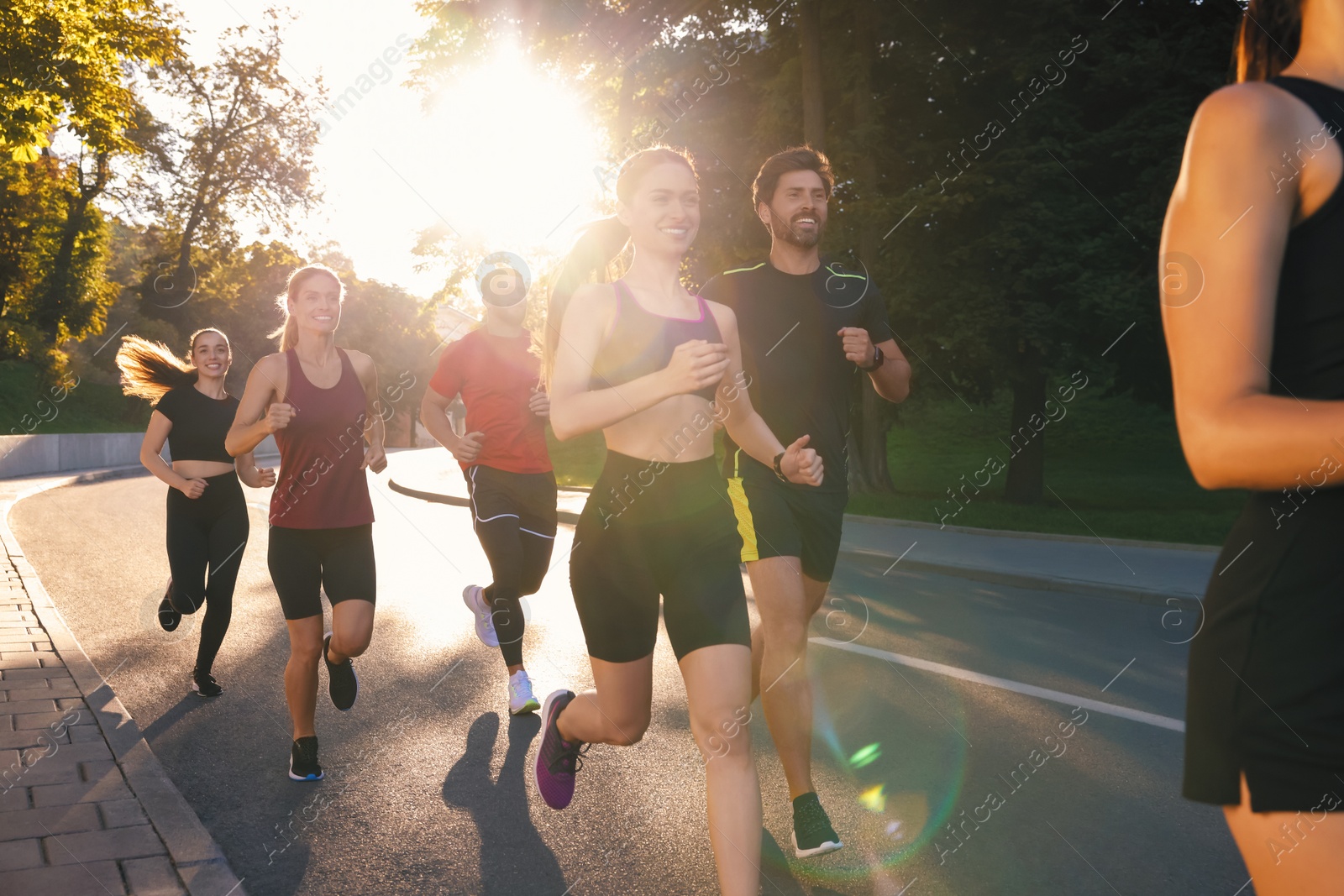 Photo of Group of people running outdoors on sunny day