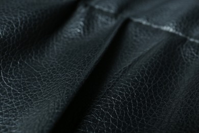 Black leather with seam as background, closeup