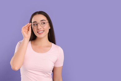 Photo of Beautiful woman wearing glasses on violet background, space for text