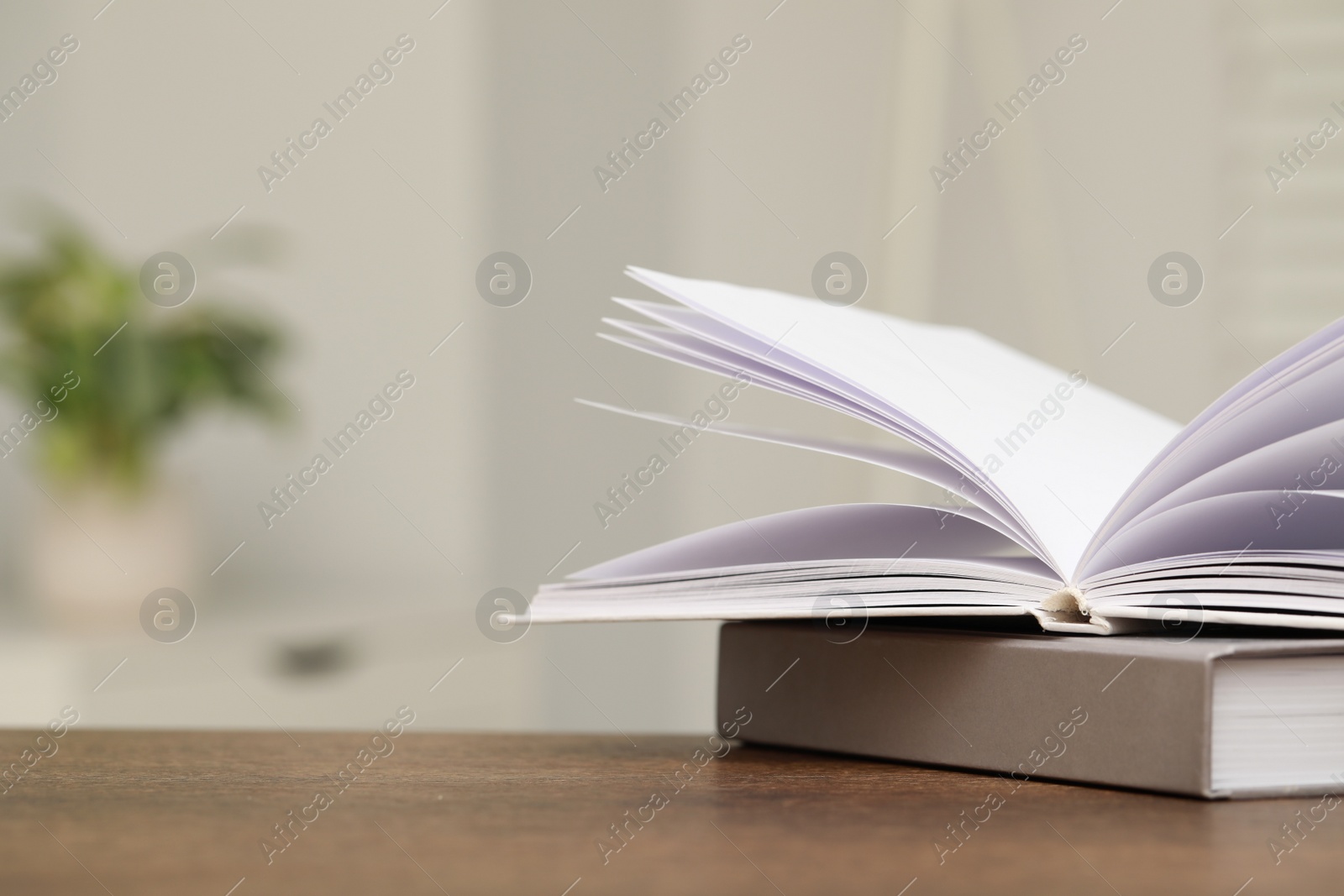 Photo of Stack of hardcover books on wooden table indoors. Space for text