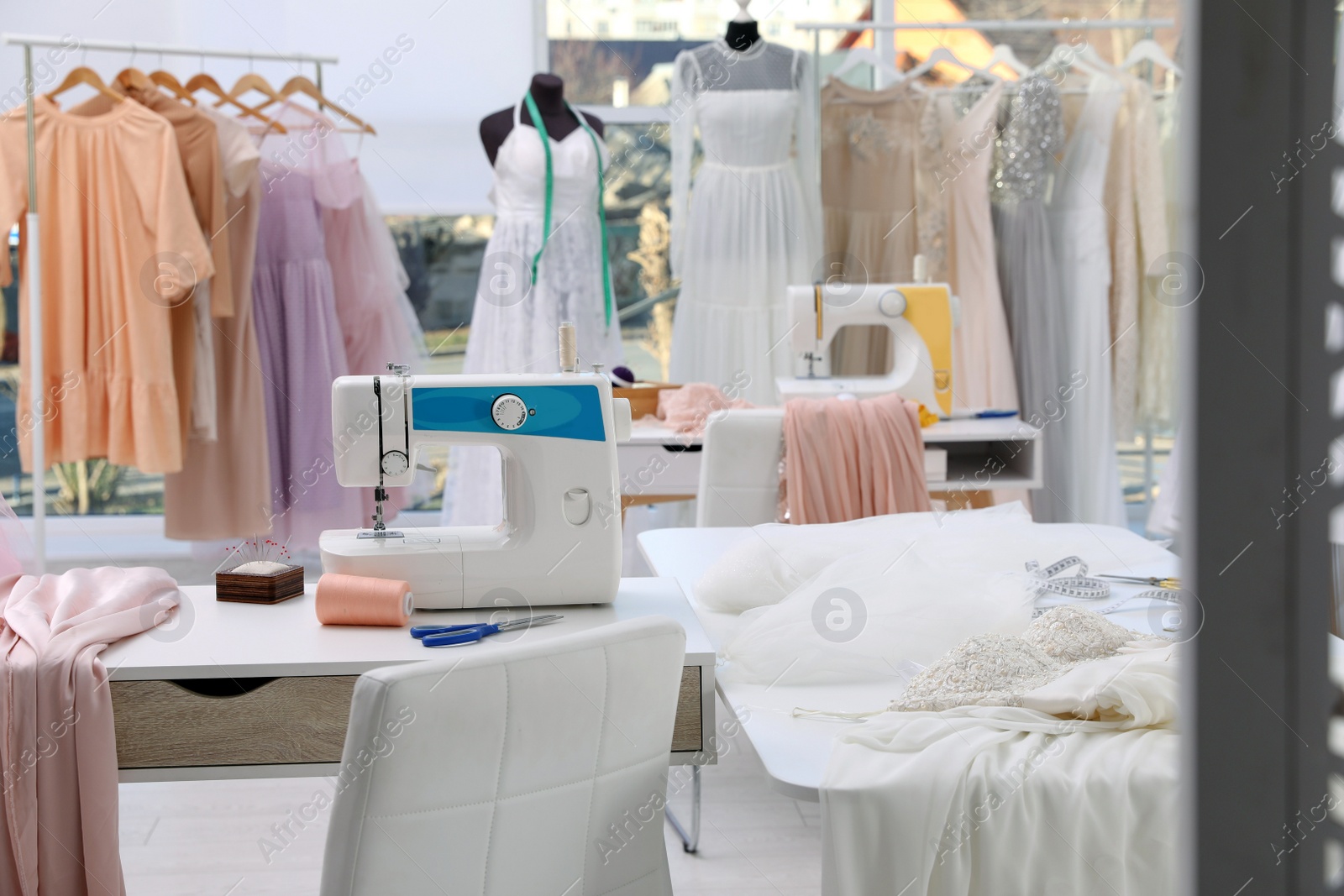 Photo of Dressmaking workshop interior with wedding dresses and equipment