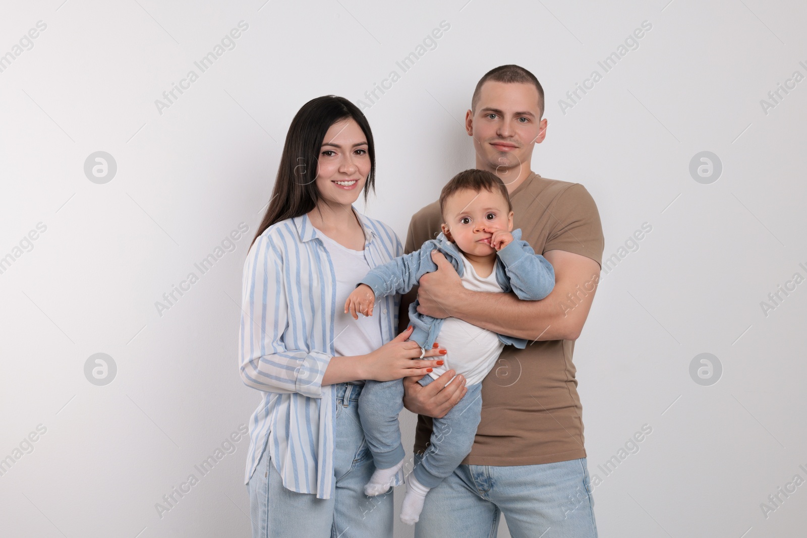 Photo of Portrait of happy family with little child on light background