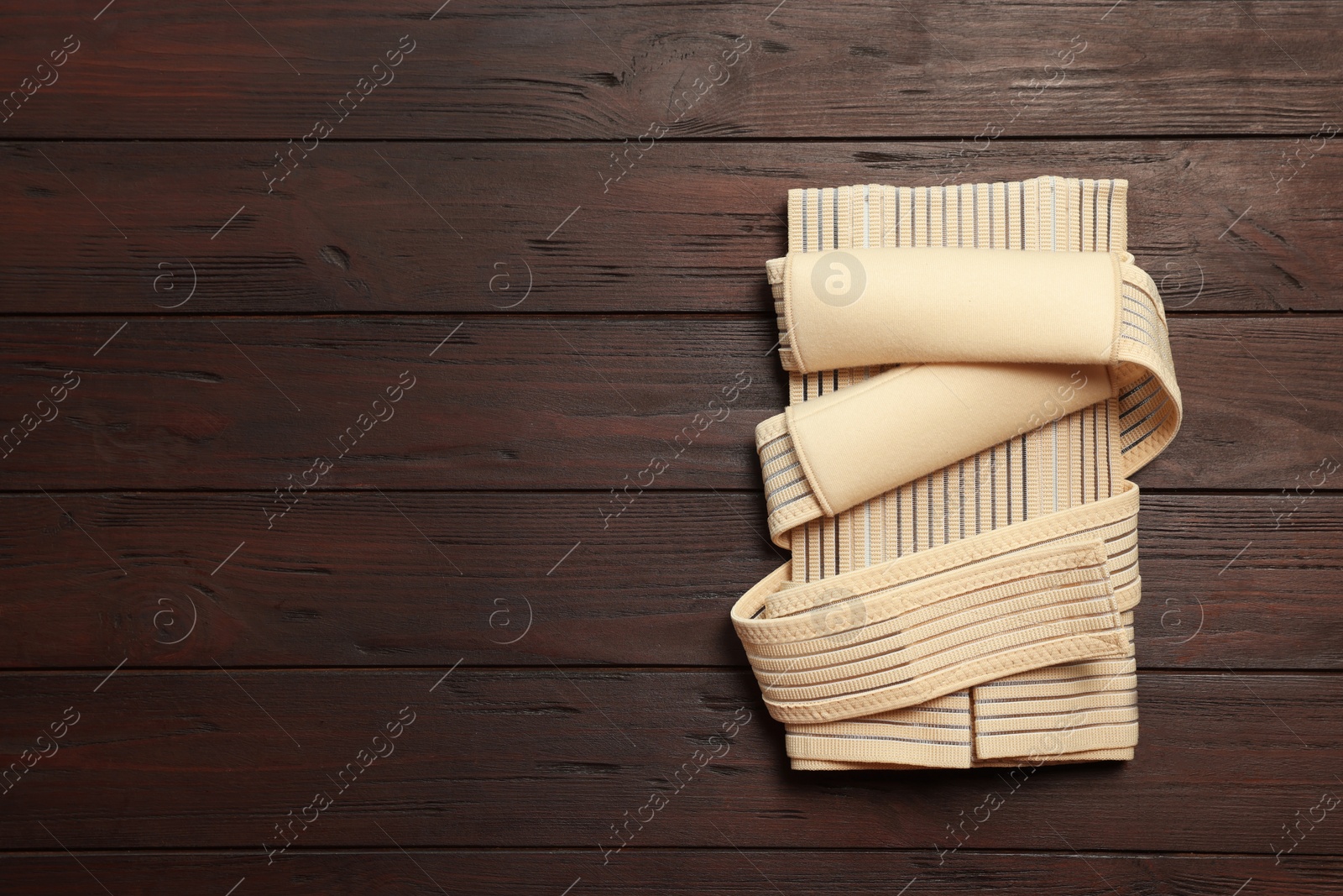 Photo of Beige posture corrector on wooden table, top view. Space for text