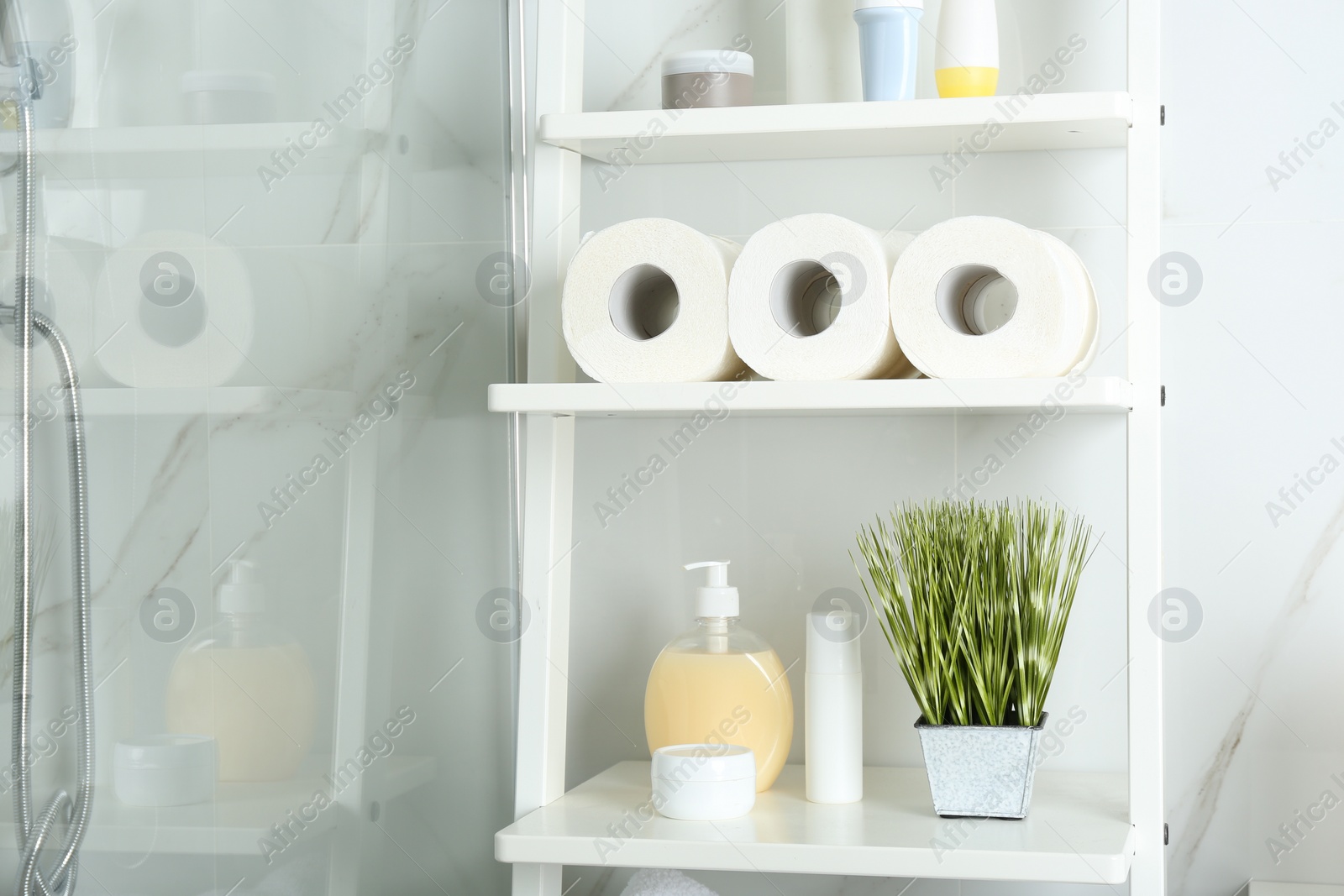 Photo of Toilet paper rolls on shelving unit in bathroom