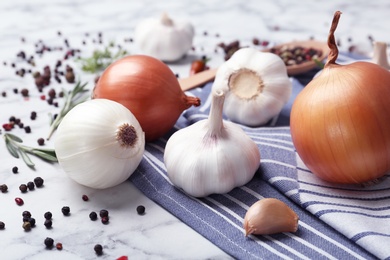 Photo of Ripe garlic and onions on marble table