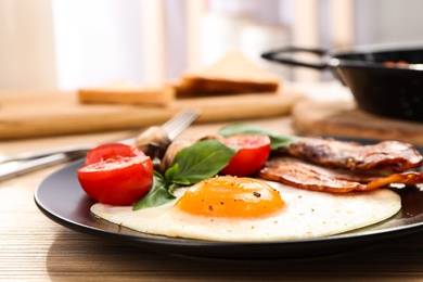 Tasty breakfast with fried egg on wooden table, closeup