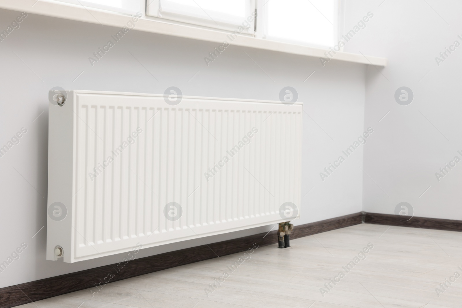 Photo of Modern radiator in room. Central heating system