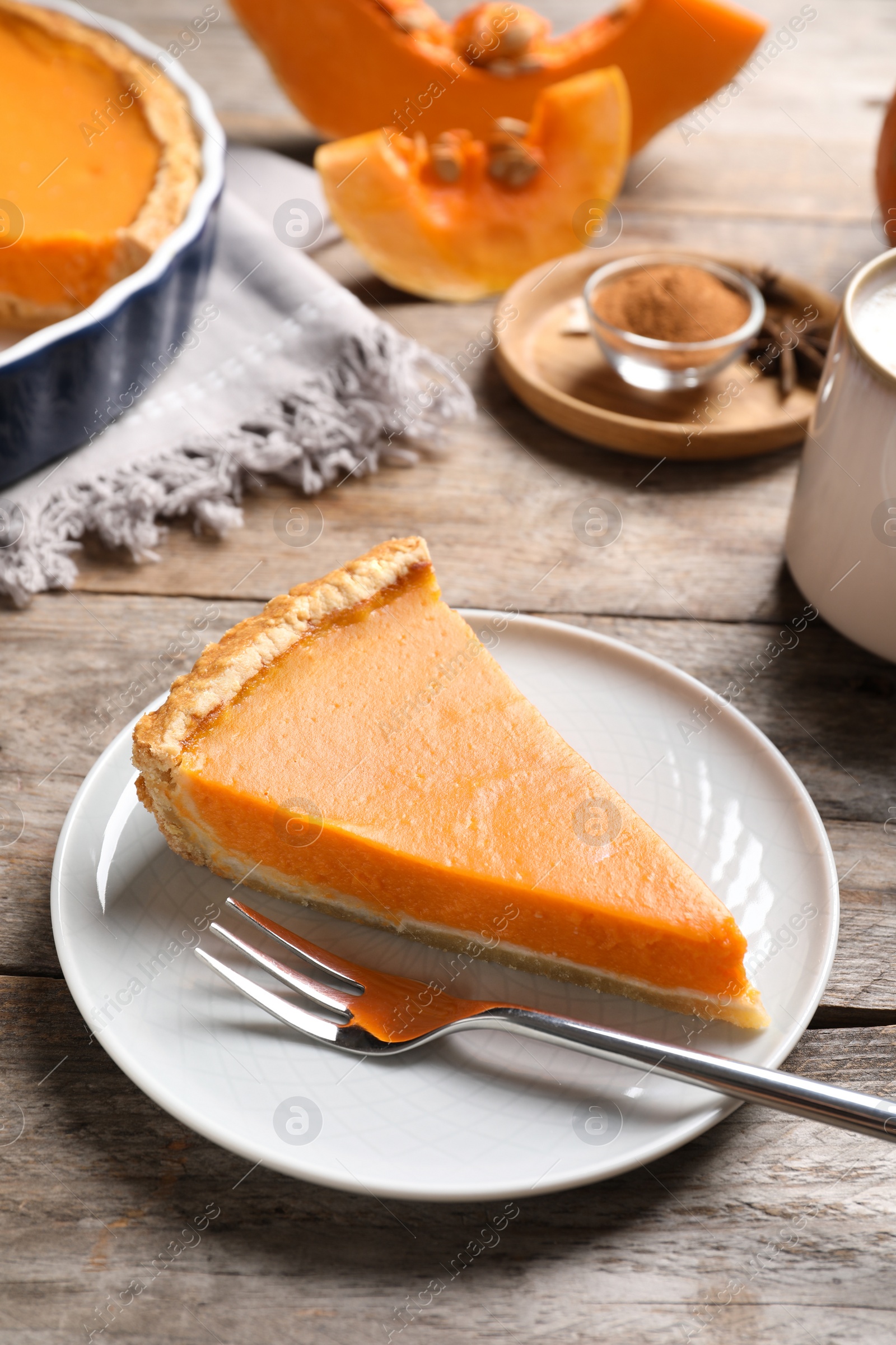 Photo of Plate with piece of fresh delicious homemade pumpkin pie on wooden table