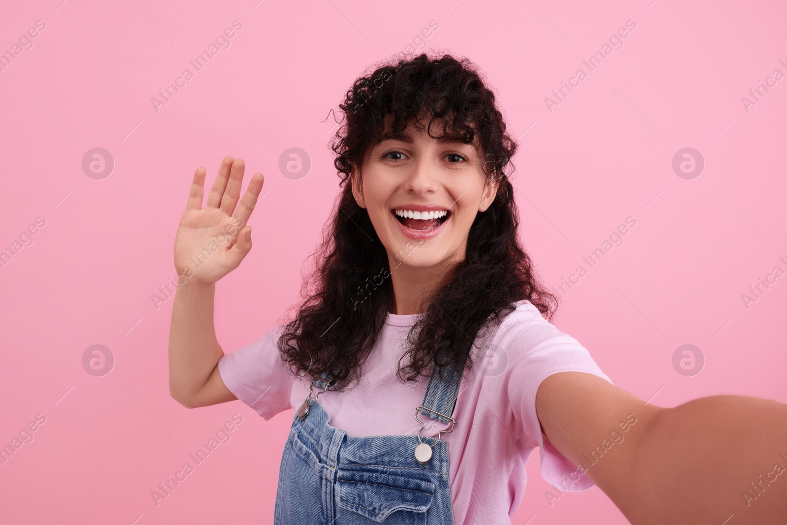 Photo of Beautiful woman taking selfie on pink background