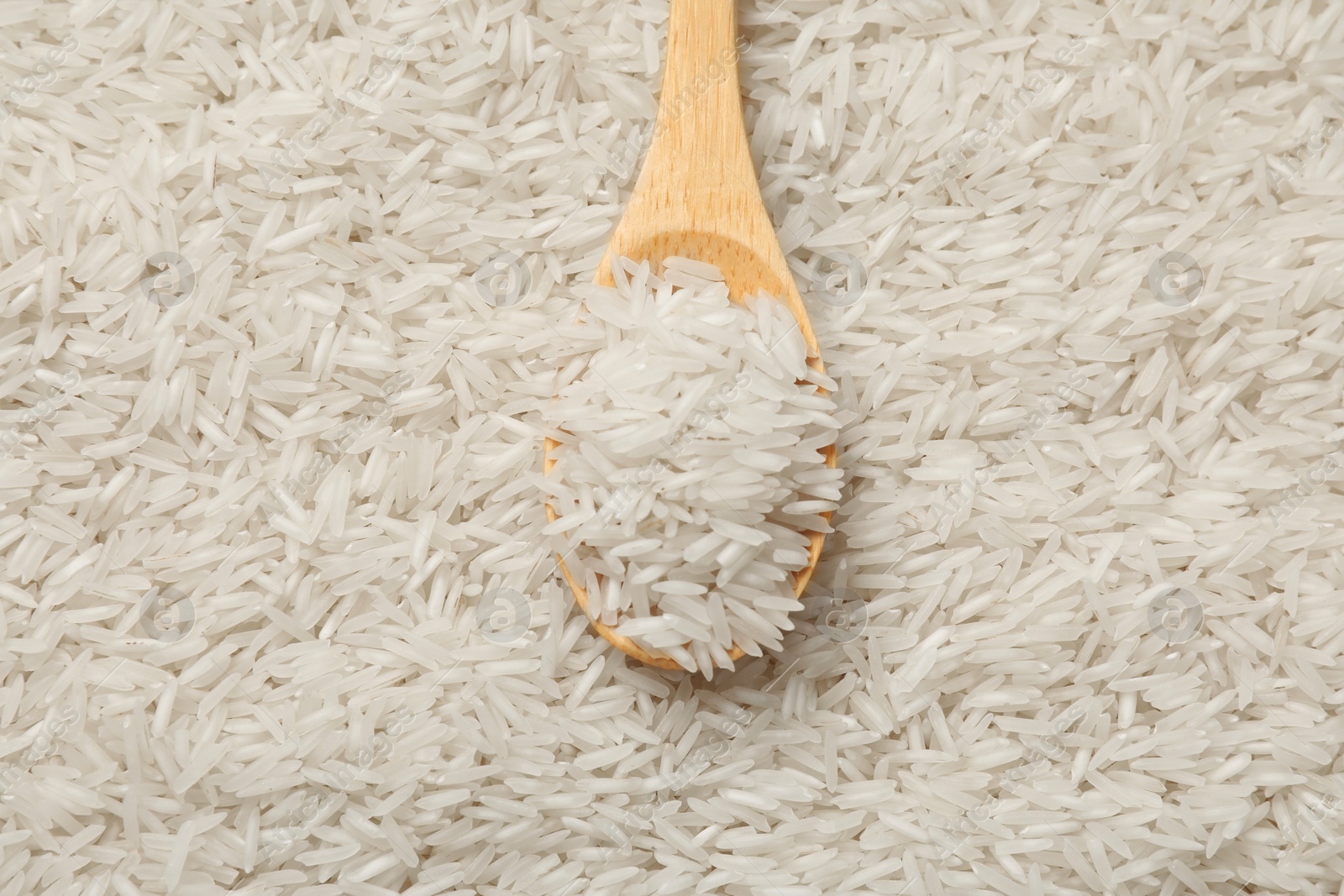 Photo of Raw basmati rice and spoon as background, top view