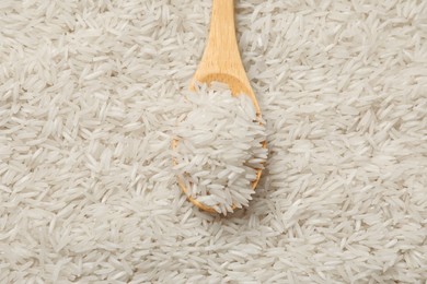 Photo of Raw basmati rice and spoon as background, top view