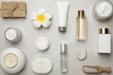 Photo of Flat lay composition with cosmetics and sea salt on grey marble table. Spa treatment