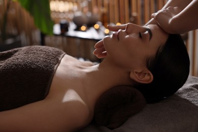 Photo of Spa therapy. Beautiful young woman lying on table during massage in salon