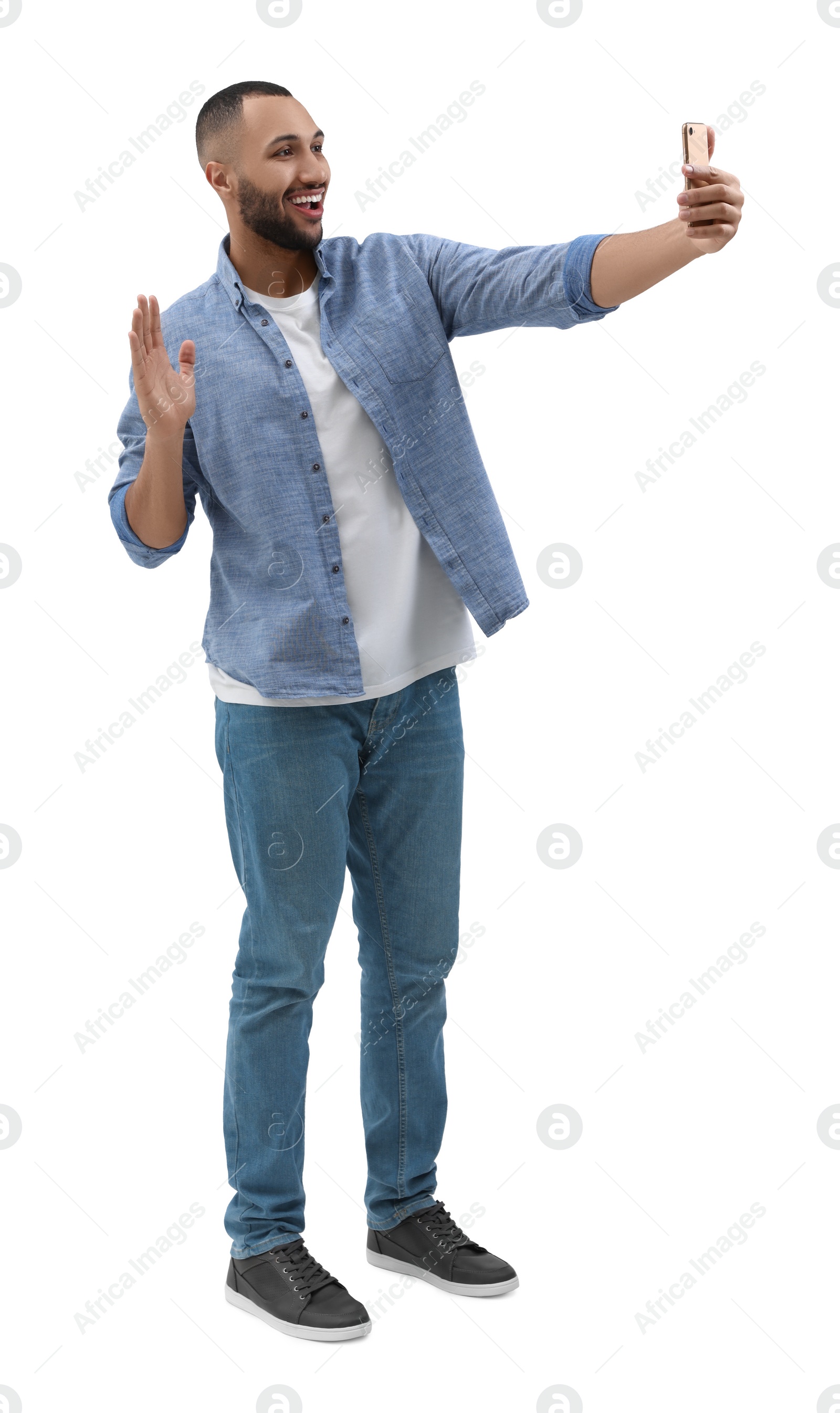 Photo of Smiling young man taking selfie with smartphone on white background