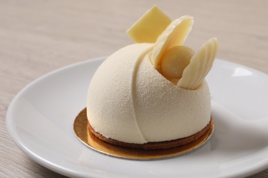 Photo of Delicious mousse cake with white chocolate on wooden table, closeup