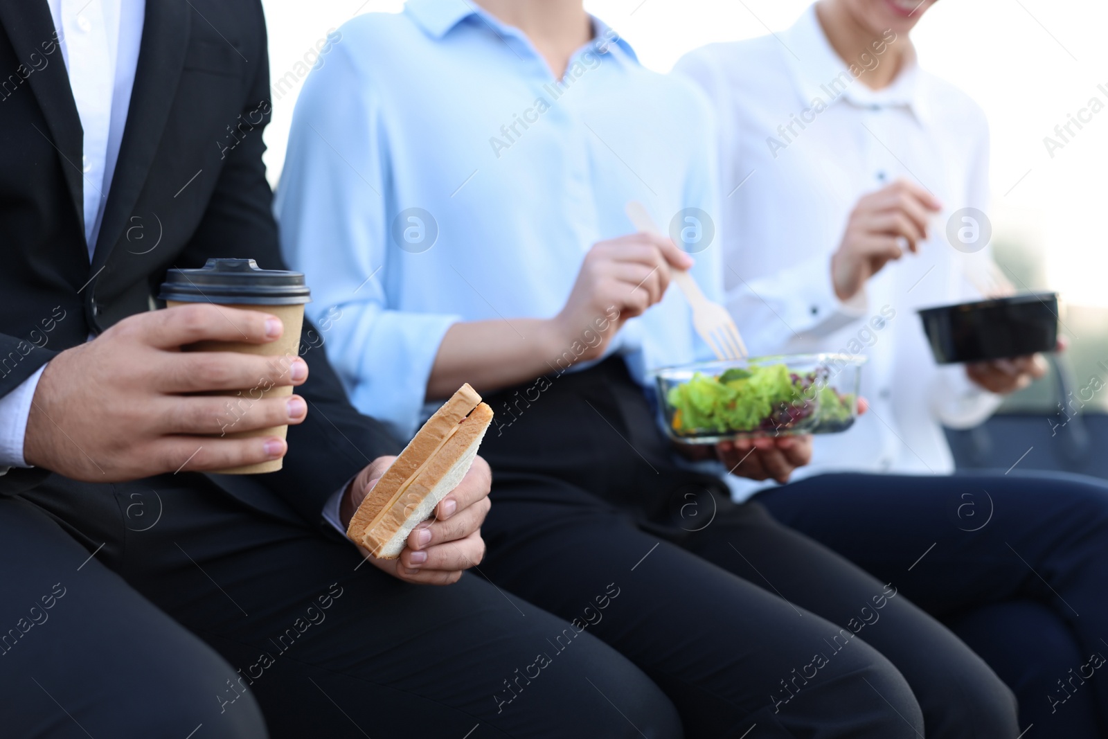 Photo of Business people having lunch together outdoors, closeup