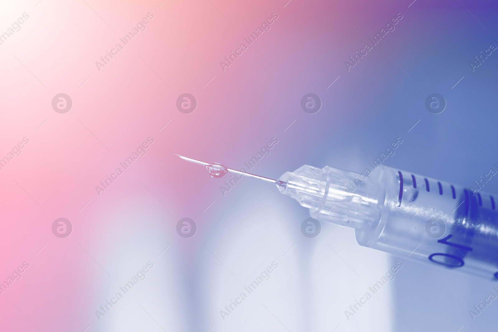 Image of Syringe with medicine against blurred background, closeup. Color toned