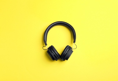 Stylish headphones on color background, top view